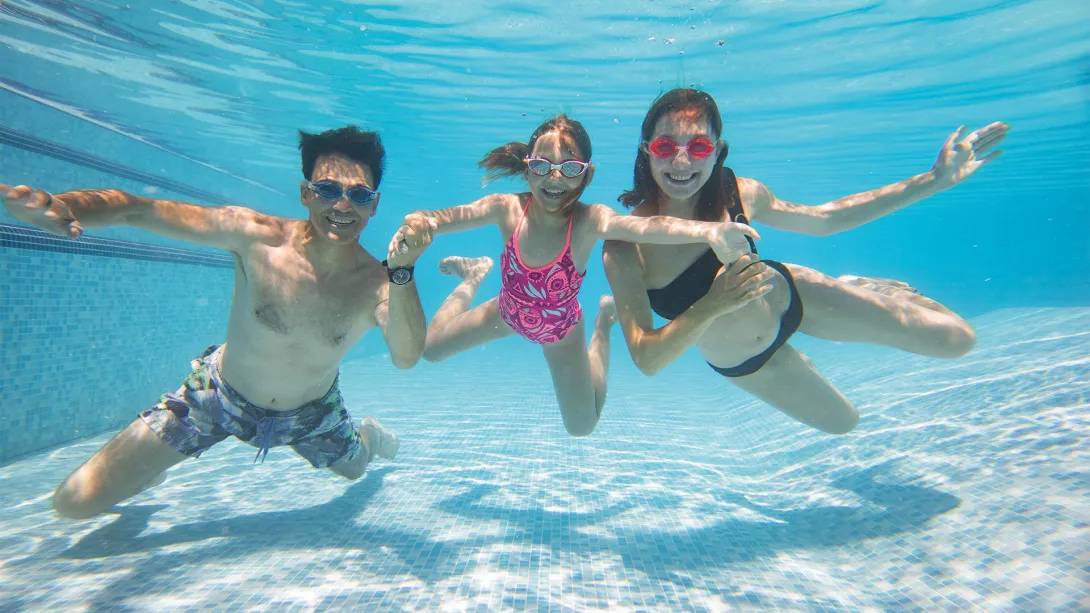 padres y hija sumergidos en el agua